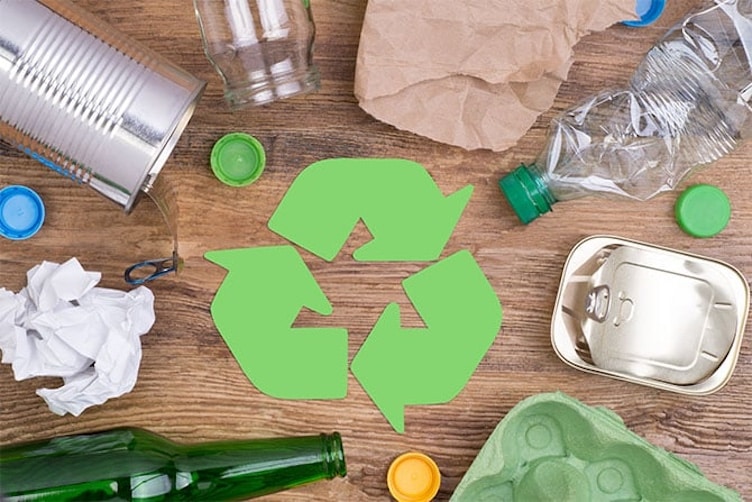 Symbolbild Kreislaufwirtschaft - mehrere Verpackungen aus verschiedenen Materialien, in der Mitte drei grüne Pfeile stehend für Recycling. Plastik recyceln