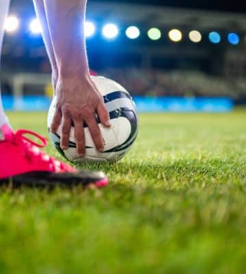 Soccer Player Putting Sports Ball On Grass