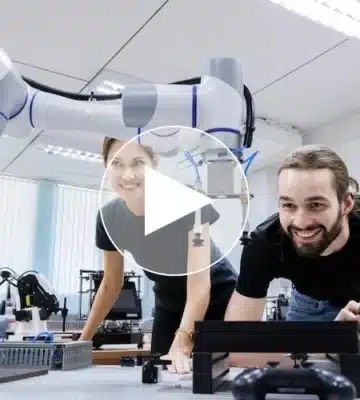 Zwei junge Auszubildende in einem modernen Ausbildungszentrum der Kunststoffindustrie arbeiten gemeinsam mit einem kollaborativen Industrieroboter an einem technischen Projekt – Fokus auf Digitalisierung, Robotik und praxisnahe Ausbildung in zukunftsorientierten Berufen.
