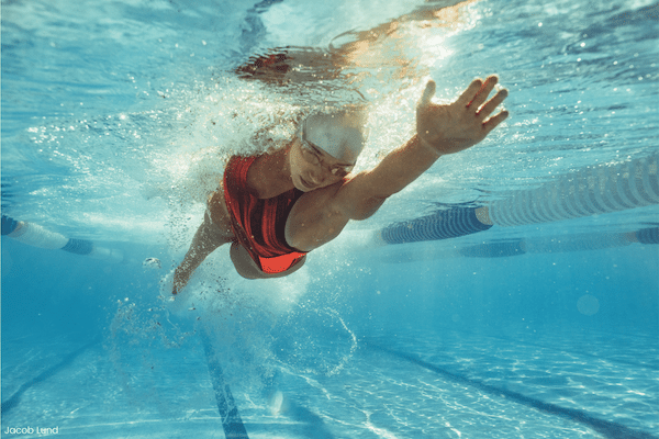 Eine Schwimmerin unter Wasser nutzt moderne Schwimmausrüstung aus Kunststoff, um Geschwindigkeit und Effizienz zu maximieren – ein Beispiel für die Rolle von Kunststoffen bei den Olympischen Spielen 2024 © Jacob Lund